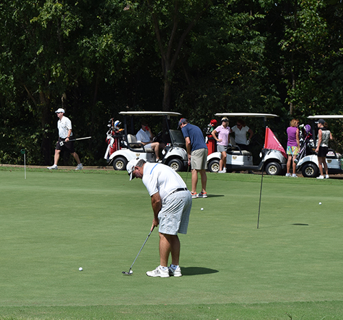 Man on green about to make a putt