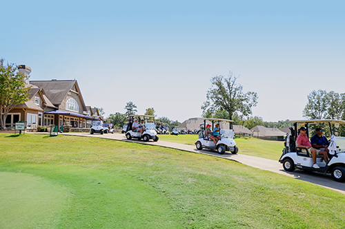 Golf carts taking off down the path from the clubhouse